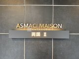 アスマチメゾン両国2 建物名を示すゴールド文字と漢字表記の看板