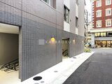 アスマチメゾン両国2 落ち着いた色合いのタイル張り外壁と照明が美しい建物エントラン