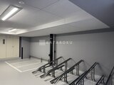 アスマチメゾン両国2 明るい照明の駐輪スペースと機械式駐車装置が備わった共用部