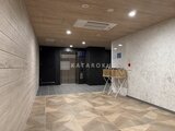 アスマチメゾン両国2 モダンな共用エントランスホール、木目調の床と壁パネルでまとめ