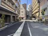 OAKLANCE森下2 建物前の駐車場から見た、周辺建物に囲まれた開放的なエントラン