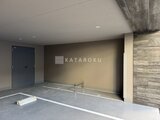 OAKLANCE森下2 木調パネルと濃紺ドアが配置された駐車場の空間