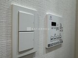 OAKLANCE森下2 白いタイル壁に設置された照明スイッチと給湯器パネル