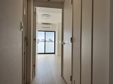 OAKLANCE森下2 廊下から見た明るい室内と都市景観を眺めるバルコニー
