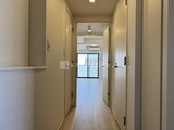 OAKLANCE森下2 複数のドアが並ぶ廊下から玄関に向かう開放的な通路