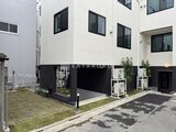 THE PALMS大島 モダンな外観の建物と開放的な駐車スペースの様子