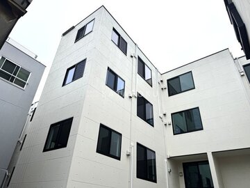 THE PALMS大島 白いタイル張りの外壁を持つ、モダンな印象の集合住宅外観