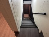 THE PALMS大島 階段上部の窓から光が差し込む共用階段通路