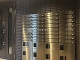 THE PALMS大島 モダンな金色のメールボックスが整然と並ぶエントランスホール