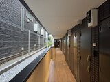 THE PALMS大島 木目調の床と黒いタイルで統一された落ち着いた雰囲気の共用廊下
