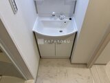 THE PALMS大島 白を基調とした洗面台と収納が備わったコンパクトな洗面脱衣室