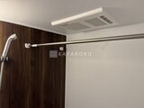 THE PALMS大島 浴室暖房乾燥機と木目調パネルが設置されたバスルーム