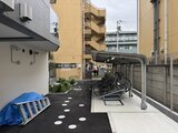 クレヴィアリグゼ蒲田西 自転車置き場とボートが配置された共用の庭園スペース