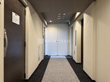 クレヴィアリグゼ蒲田西 落ち着いた色調の壁と明るいフロア照明が特徴的な共用廊下
