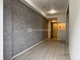 クレヴィアリグゼ蒲田西 グレー壁と木目フローリングの落ち着いた廊下空間