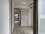 クレヴィアリグゼ蒲田西 明るい照明と落ち着いた木調フローリングが印象的な廊下空間