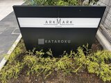 アークマーク大塚 物件名入りの黒い建物サイン看板と植栽が並ぶエントランス周辺