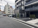 アークマーク大塚 前面道路から見たモダンなエントランスとカーポート