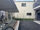 アークマーク大塚 駐輪場とアスファルト舗装の広場を備えた共用部の様子