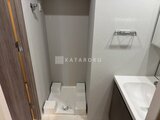 アークマーク大塚 洗濯機置き場と白系の洗面台が配置されたコンパクトな洗面所