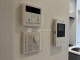 アークマーク大塚 壁に取り付けられた給湯パネルと照明スイッチ、インターホン