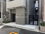 CREATIF蔵前 落ち着いた色合いのタイル張り外壁とスロープ付きのエントランス