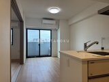 CREATIF蔵前 開放的なキッチンから眺める、明るい窓と都市風景が広がるリビン