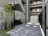 リビオメゾン浅草橋 駐車場スペースと建物外観を写した開放的な共用部の様子