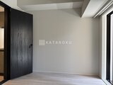 リビオメゾン浅草橋 モダンな黒いドアと明るい窓を備えたゆとりのある室内空間