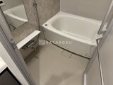 リビオメゾン浅草橋 白い浴槽と落ち着いた配色のタイル張りのバスルーム