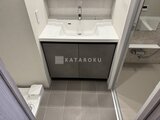 リビオメゾン浅草橋 白い洗面ボウルと黒い収納キャビネットの洗面台