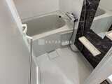CREATIF本所吾妻橋 黒い壁パネルと白いバスタブが配置されたシンプルなバスルーム