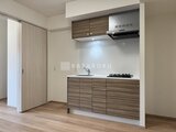 CREATIF本所吾妻橋 木目調のキッチンと洋室への引き戸が配置されたコンパクトなキッ
