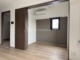 CREATIF本所吾妻橋 落ち着いた色合いの壁と明るい木目床の洋室空間