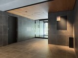 コンフォリア・リヴ押上ノース モダンなタイル張りのエレベーターホール、木目調天井が落ち着い