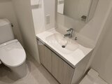 コンフォリア・リヴ押上ノース 清潔感のある洗面台と toilet が並ぶコンパクトな洗面脱