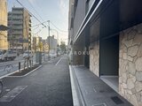 エスレジデンス王子イネーブル 前面道路から見た建物エントランスと周辺の街並み