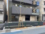 エスレジデンス王子イネーブル 前面道路から見たモダンな建物外観と石造りのエントランス
