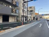 エスレジデンス王子イネーブル 前面道路から見た建物外観と駐車場エントランス