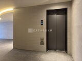 エスレジデンス王子イネーブル モダンなデザインのエレベーターホール、落ち着いた色調の壁面