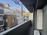 エスレジデンス王子イネーブル 明るい日中に周辺建物を見渡せるバルコニーの様子