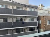 エスレジデンス王子イネーブル 白タイル調の外壁とバルコニーが特徴の3階建て共同住宅の外観