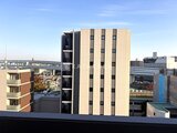 エスレジデンス王子イネーブル 周辺建物を背景にした建物外観のモダンな印象