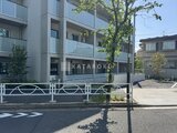 エスレジデンス駒場東大前 モダンな外観の建物と緑に囲まれた前面道路の様子