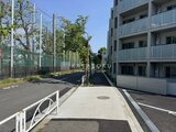 エスレジデンス駒場東大前 建物隣の開放的な敷地に緑が映える駐車場エリアの様子