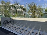 エスレジデンス駒場東大前 駐輪場に整列した自転車ラックと開放的な共用スペースの様子