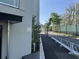 エスレジデンス駒場東大前 建物外観と緑を配した開放的なアプローチの様子