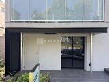 エスレジデンス駒場東大前 黒いフレームの開放的なエントランスと駐車スペースの様子
