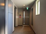 エスレジデンス駒場東大前 落ち着いた色調の共用廊下と防火扉、採光窓のある空間