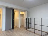 エスレジデンス駒場東大前 開放的なロフト空間に複数の居室入口と黒いスチール手すりが備わ